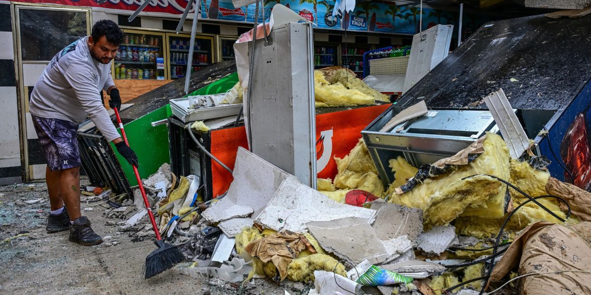 Man Cleans Debris Inside A Gas Station Store 