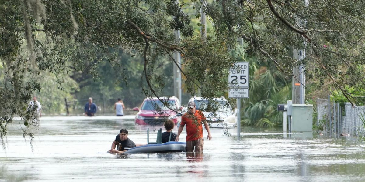 Man Tows An Air Mattress With People On It Through Flooded Streets