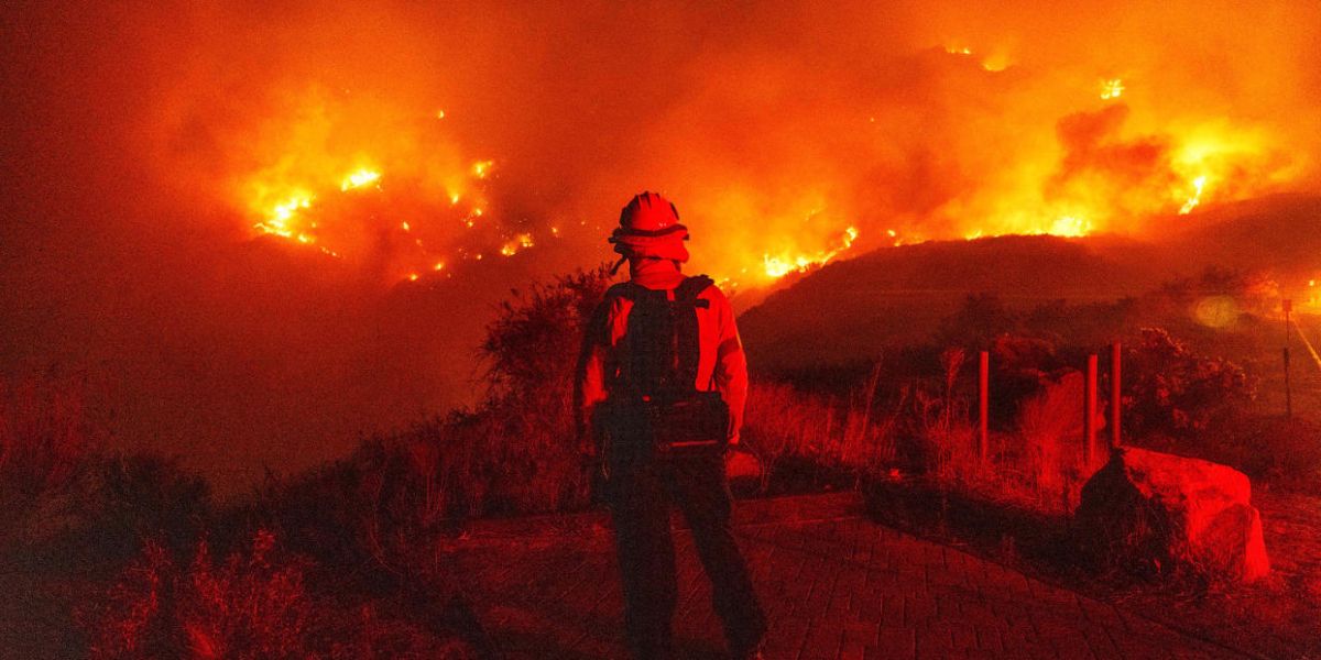 Firefighter monitoring a burning hillside